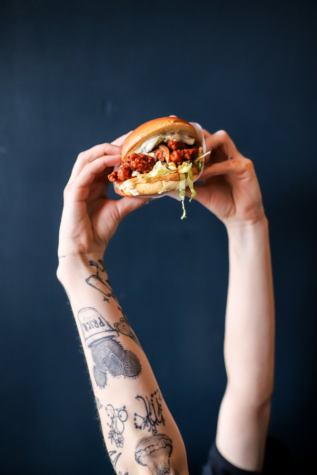 Hanks burger held up against a navy backdrop